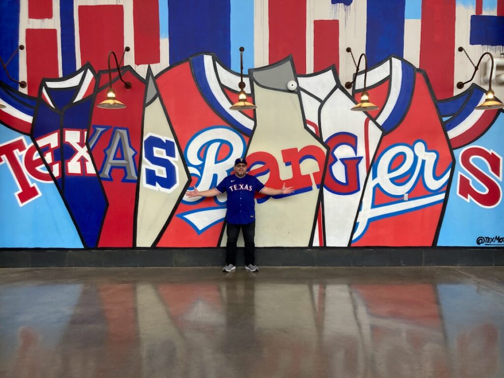 Standing in front of the Texas Rangers mural